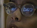 Closeup photo of student reading with a CCTV, image reflected in his glasses