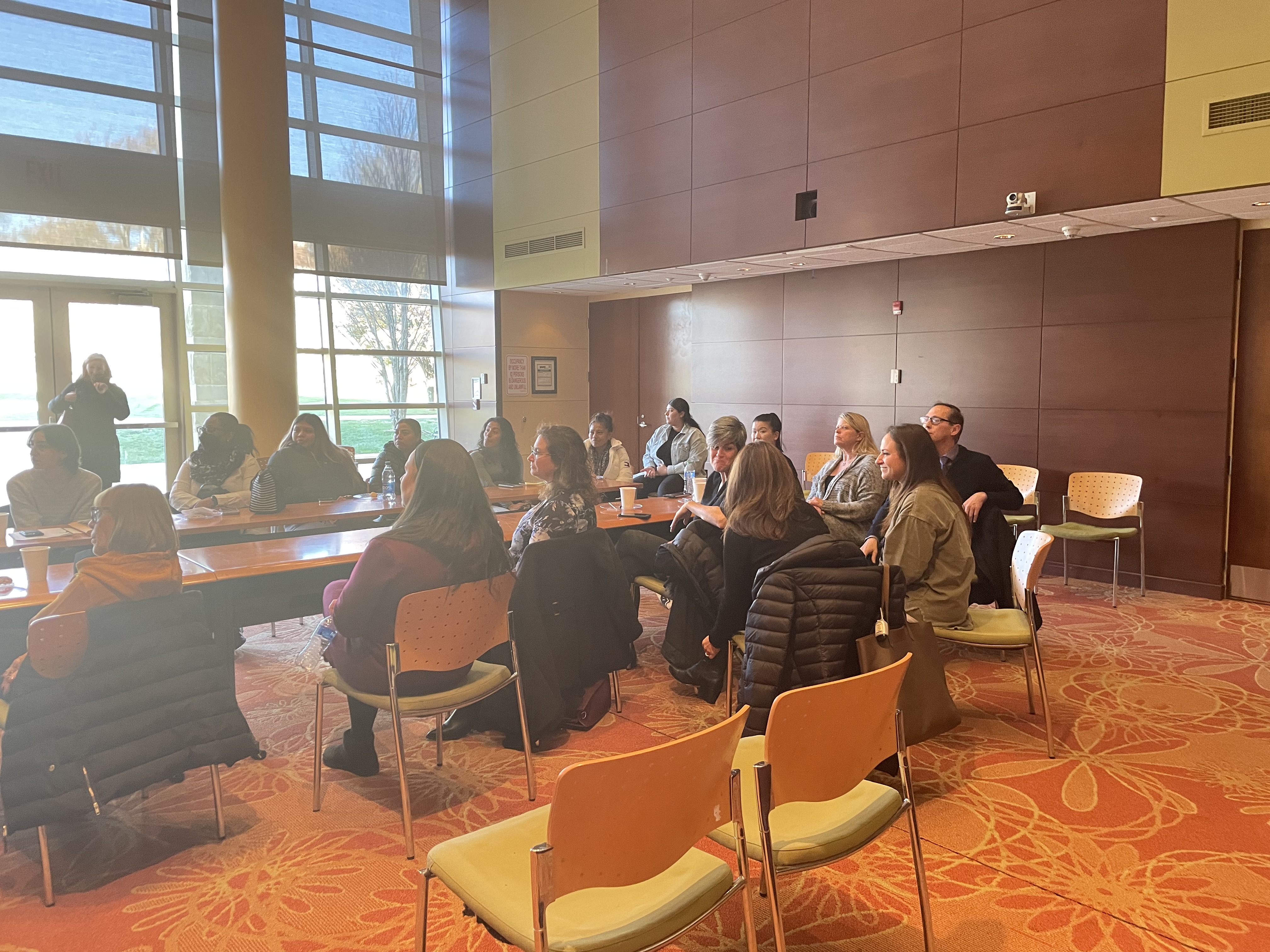 Photo of people sitting arround a table.