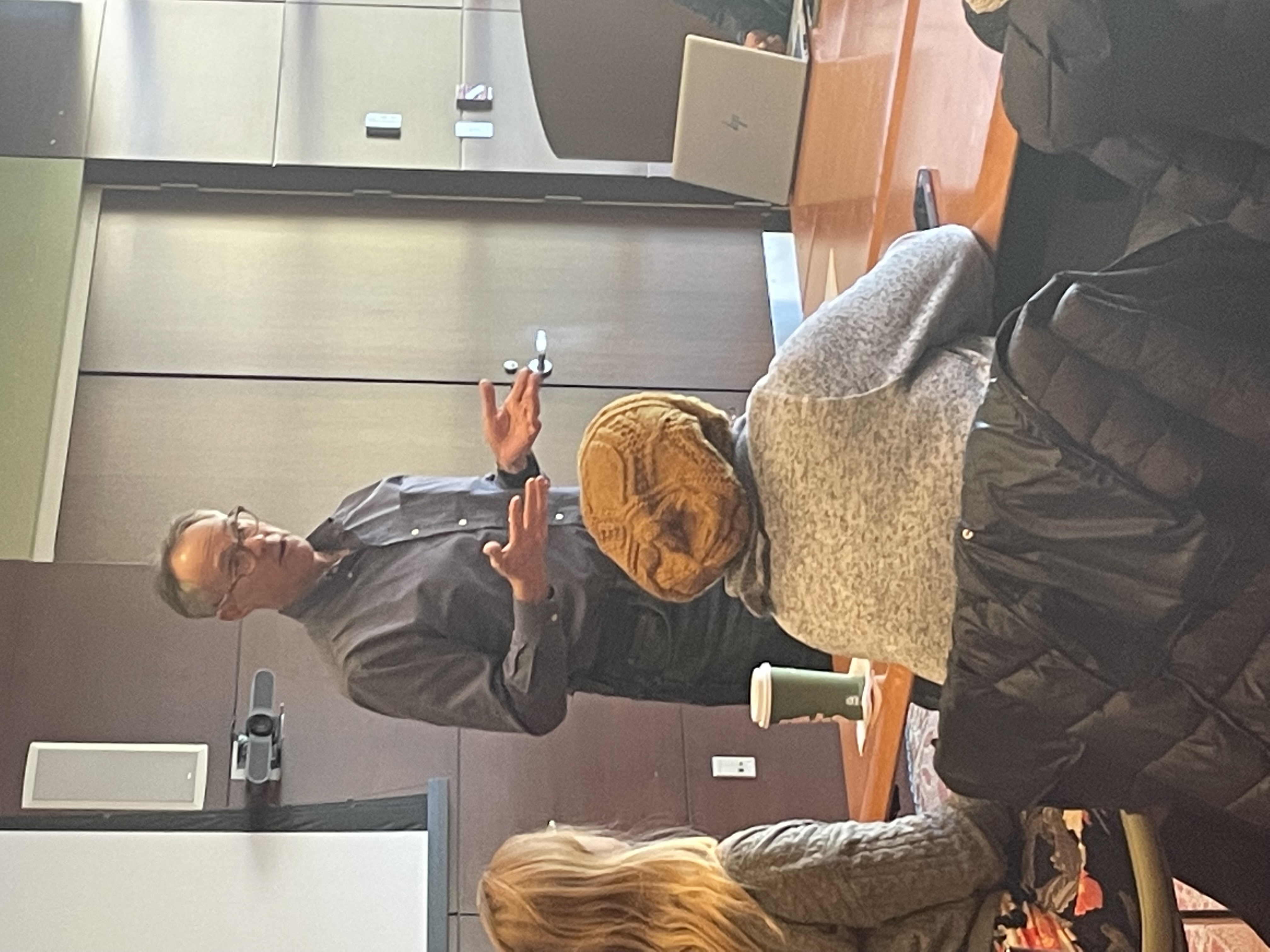 Photo of a man addressing a group of people.