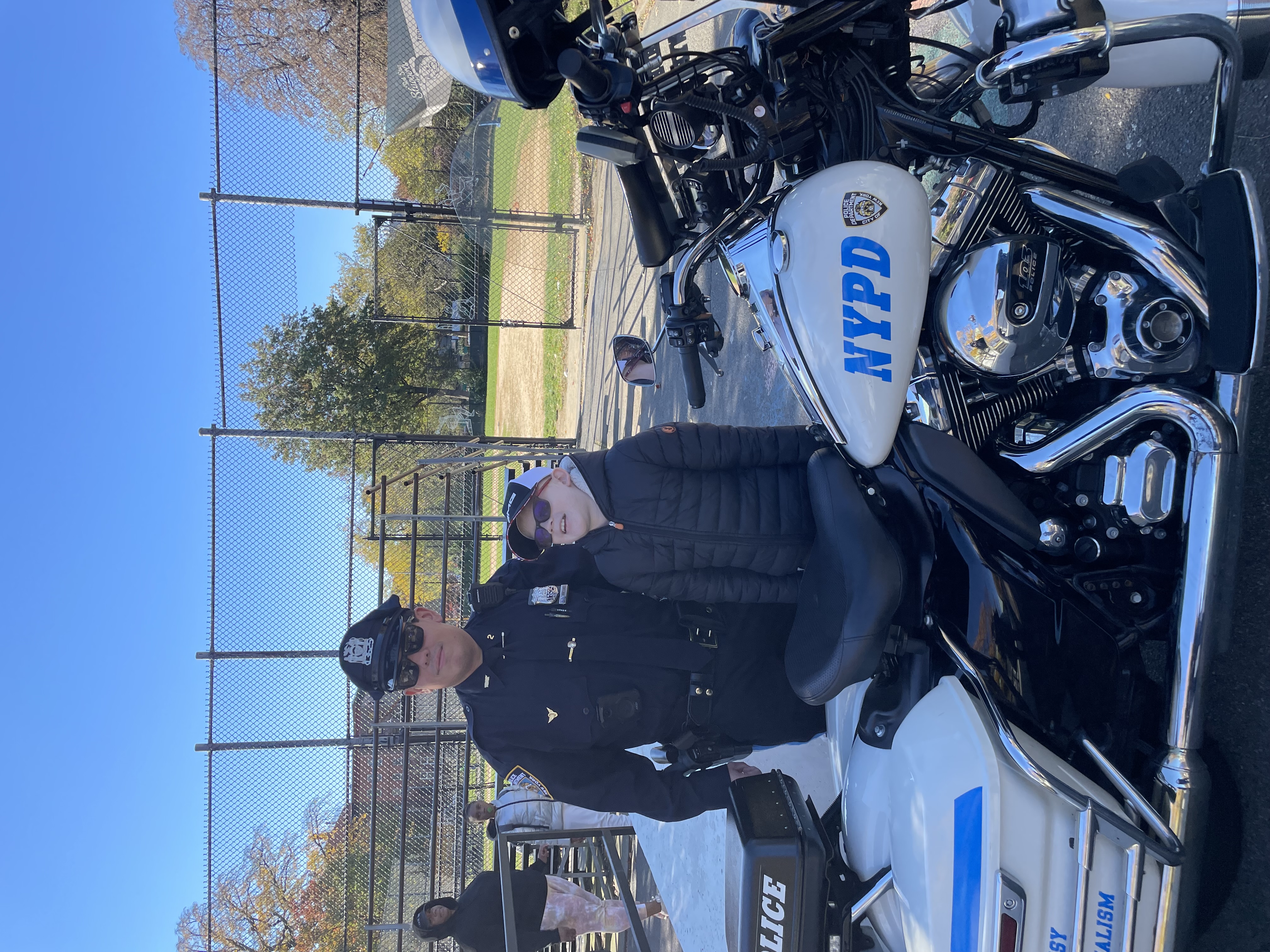 Photo of a police officer and a yong student posing for a picture