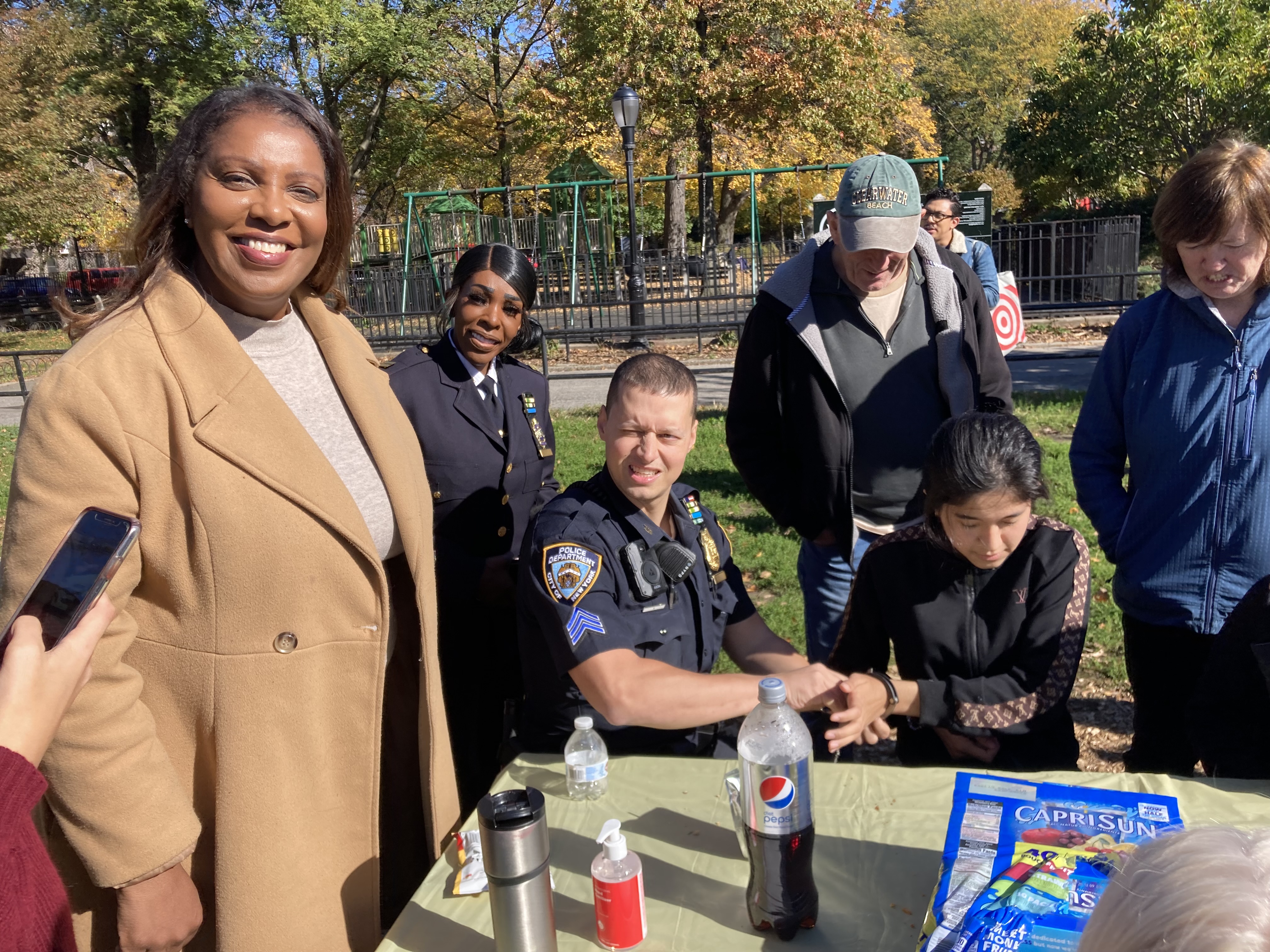 Photo of a group posing for a picture seated around a picknick table.